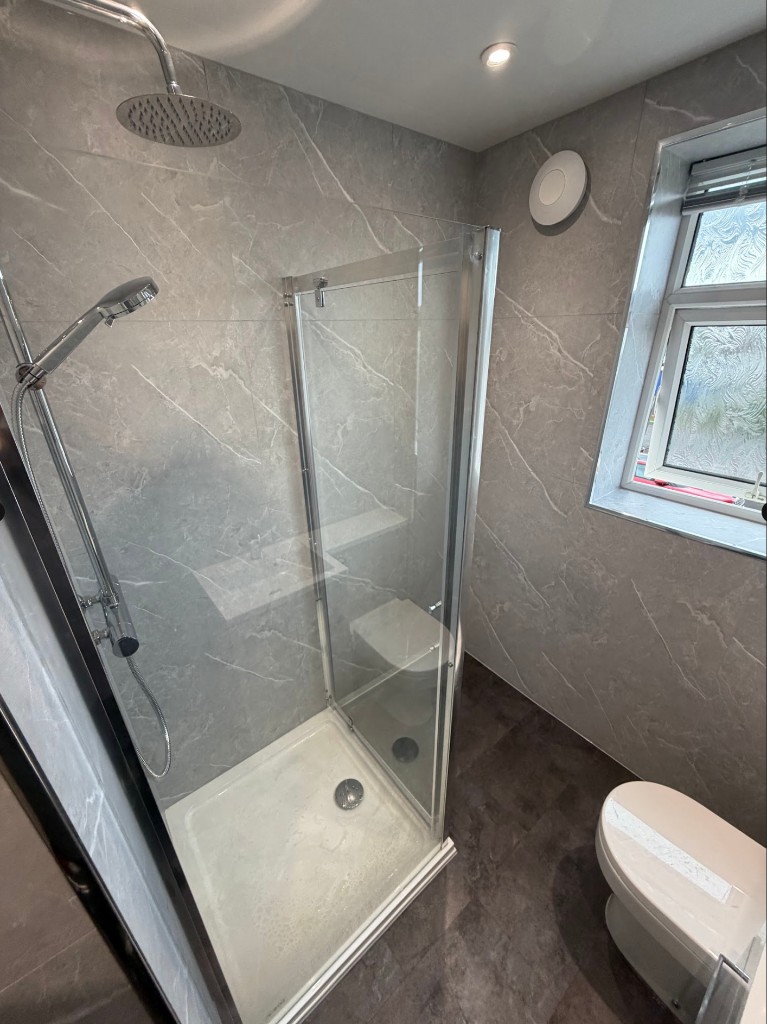 Walk-in shower installation in Longbenton, Newcastle with Amani tile-effect panels and chrome glass shower enclosure
